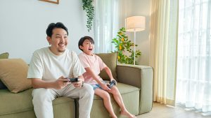 Father and son play games using Oasis Broadband Internet.